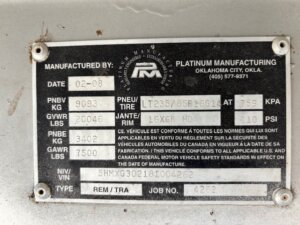 A metal manufacturer’s label from Platinum Manufacturing, featuring model and tire info in English and French for Stock Trailers, with fields for date, tire size, pressure, weight ratings, VIN, type, and job number. -Stillwater Trailer Sales