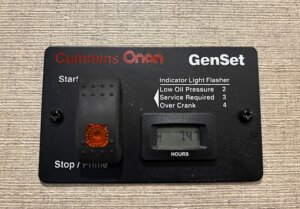 A Cummins Onan GenSet control panel with start/stop switch, indicator lights for low oil pressure, service required, over crank, and an hour meter displaying 747 hours—ideal for horse and livestock trailer sales or new and used trailers. -Stillwater Trailer Sales