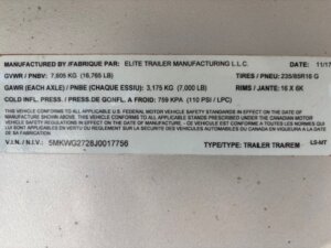 A trailer information label for the Elite 4 Horse trailer showing manufacturer, date, tire size, gross vehicle and axle weight ratings, rim size, cold tire pressure, VIN, and vehicle type in both English and French. -Stillwater Trailer Sales