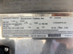 A metal label for a Sundowner 6 Horse trailer displays details like manufacture date (2/3/2006), VIN number, tire size (LT235/85R16), weight ratings, and other specs, provided in both English and French. -Stillwater Trailer Sales