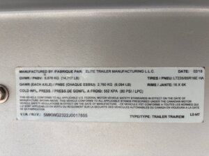 A close-up of a vehicle information label on an Elite 3 Horse trailer, showing manufacturing details, tire size, weight ratings, and VIN in both English and French. The label includes the date 02/18 and type: Horse Trailer. -Stillwater Trailer Sales
